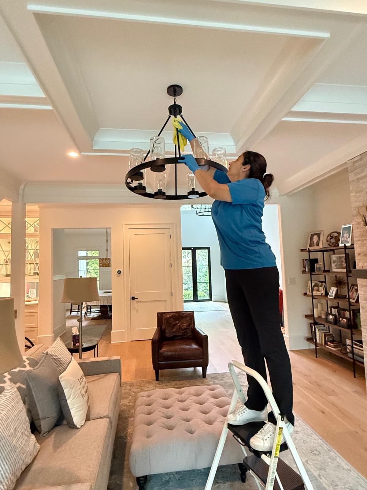 Valeria cleaning a living room chandelier