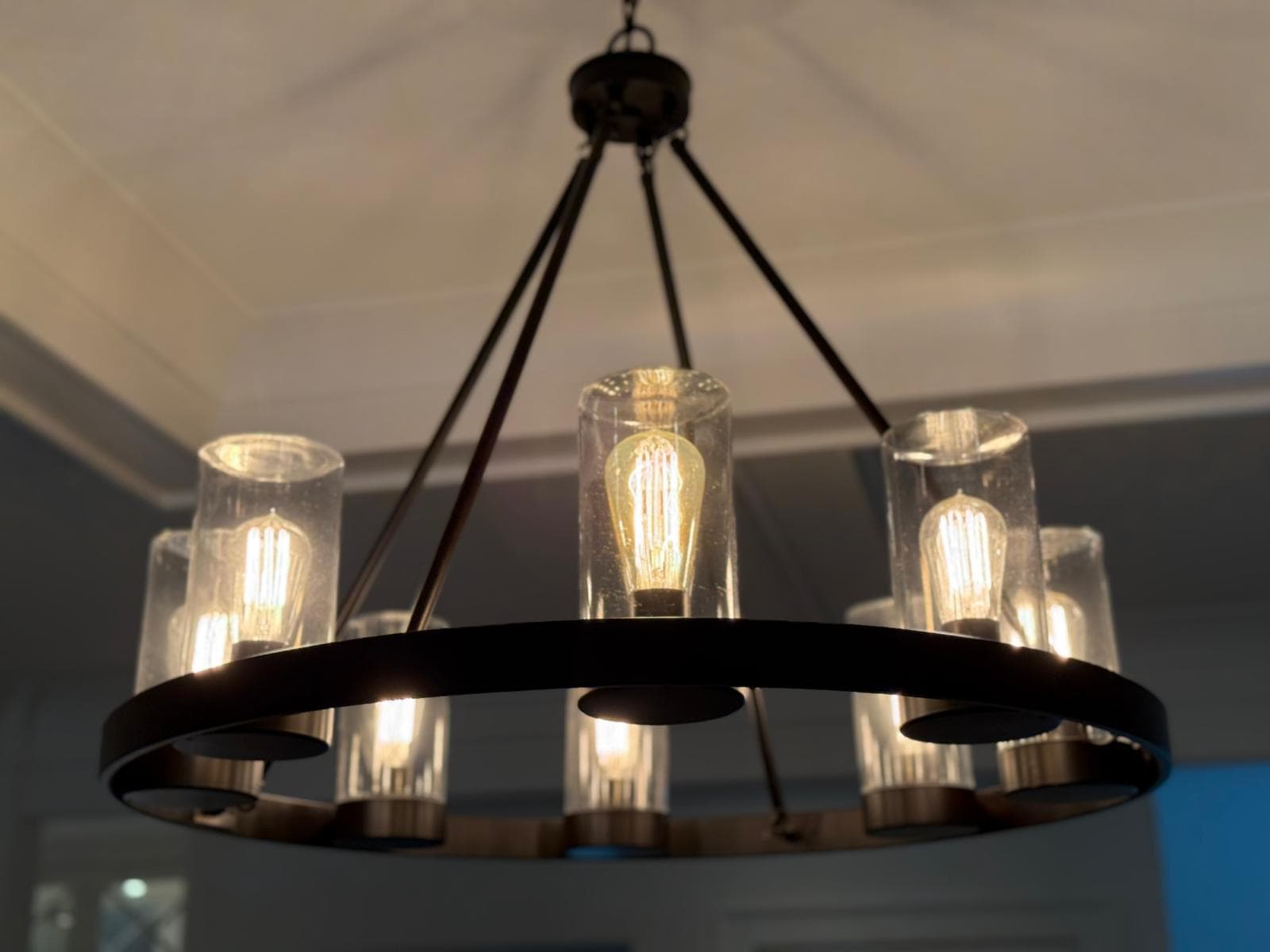 Detailed dusting of a wagon-wheel chandelier after cleaning