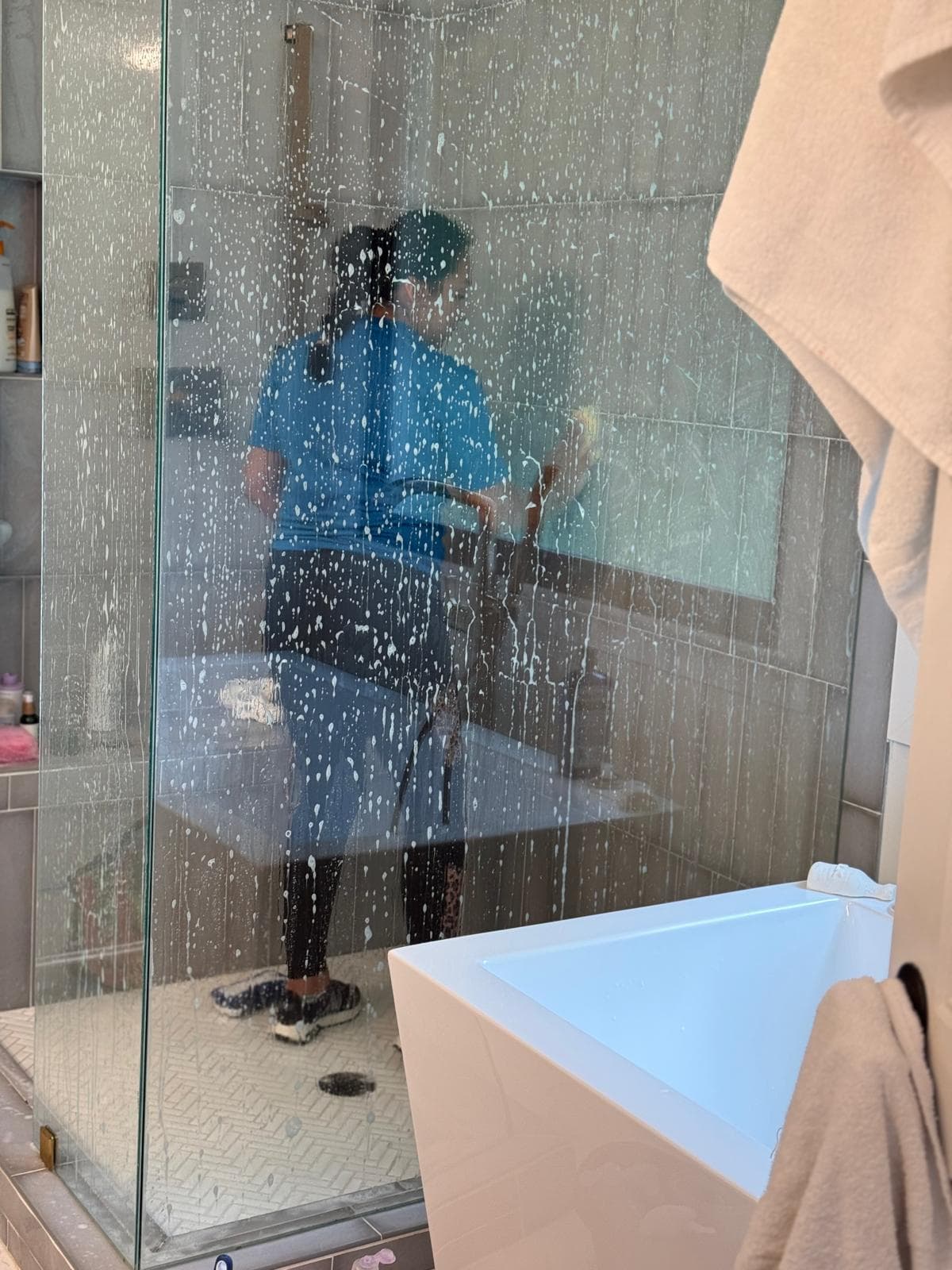 Glass shower walls being cleaned during a bathroom visit