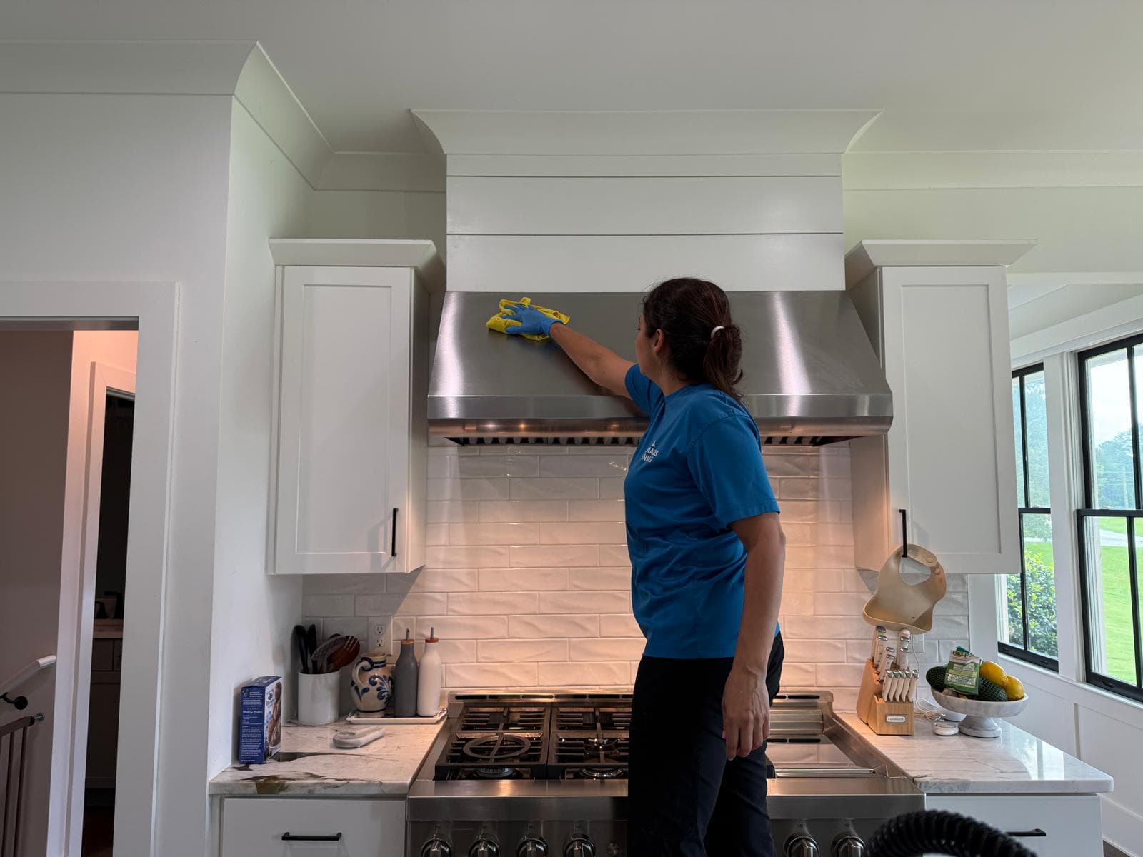 Valeria cleaning a stainless steel range hood